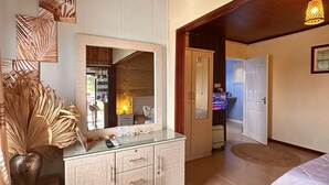 Un salon moderne avec un plafond en bois, une table basse en verre, un banc blanc et un grand miroir.