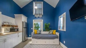 Un dormitorio pequeño con cama, televisión y ventana.