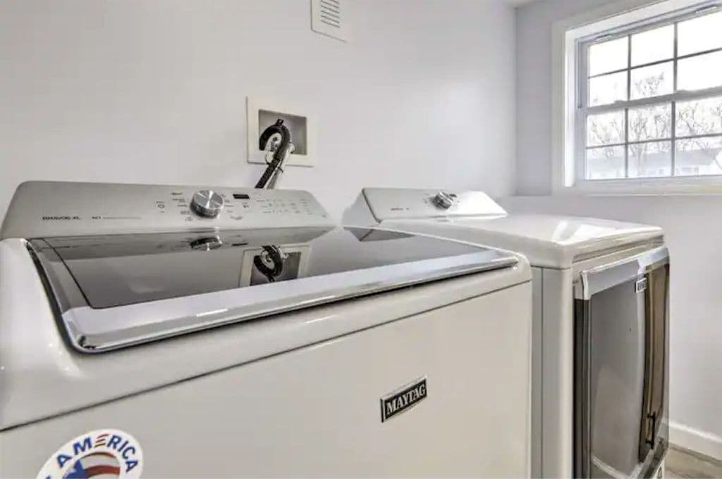 A front view of a Maytag washer and dryer unit in a room with a window.