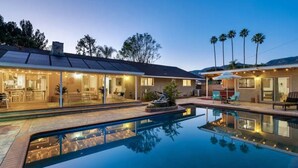 A modern house with a swimming pool, solar panels, and outdoor seating. - Luxury Tropical Modern Pool Estate/NO PARTIES (San Bernardino)