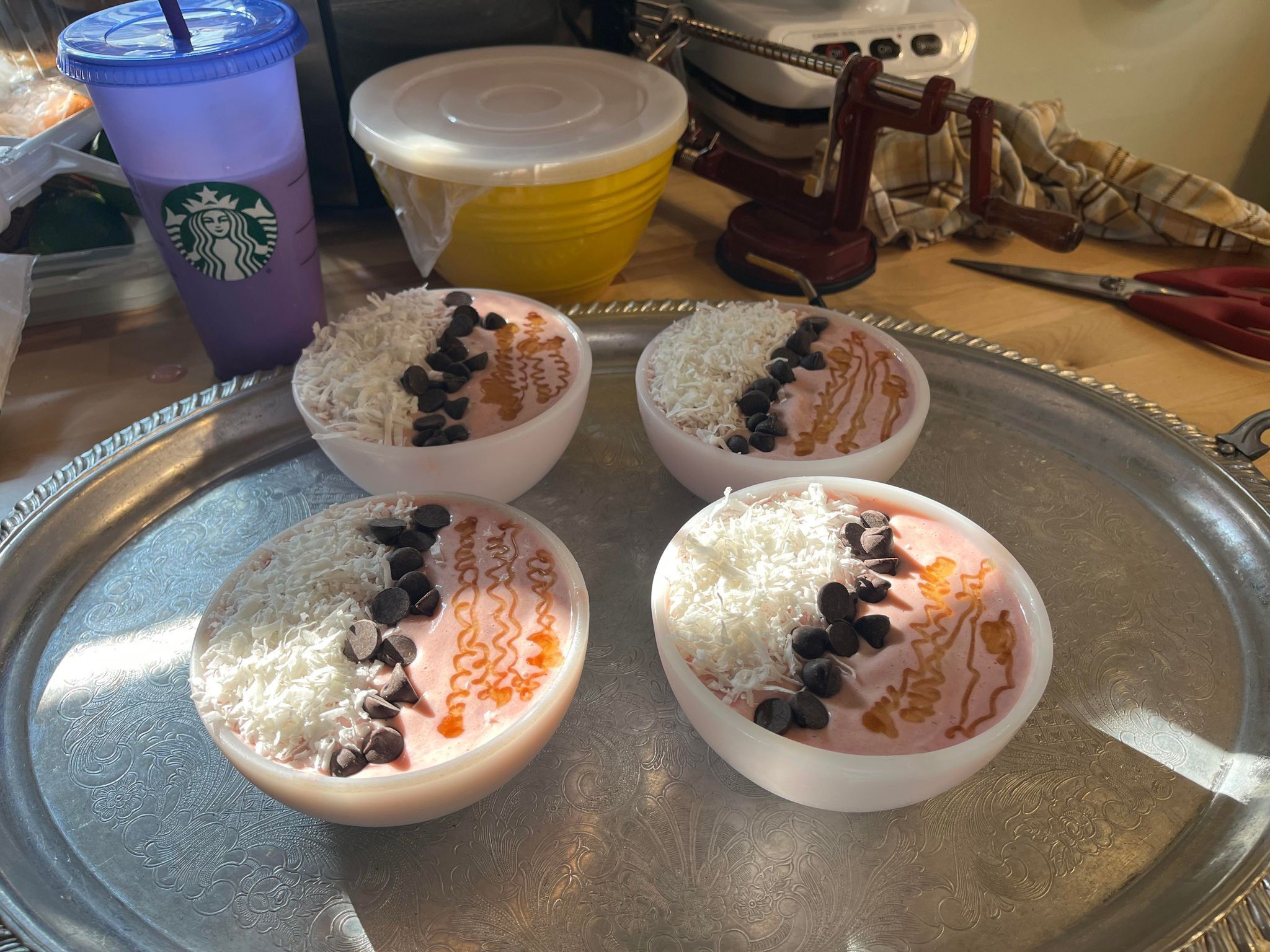 Cuatro tazones de postre con ingredientes adicionales sobre una bandeja.