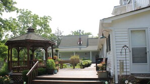 A gazebo with steps leading to a porch, surrounded by potted plants and a stone wall. - The Sautee Inn Bed & Breakfast (Sautee Nacoochee)