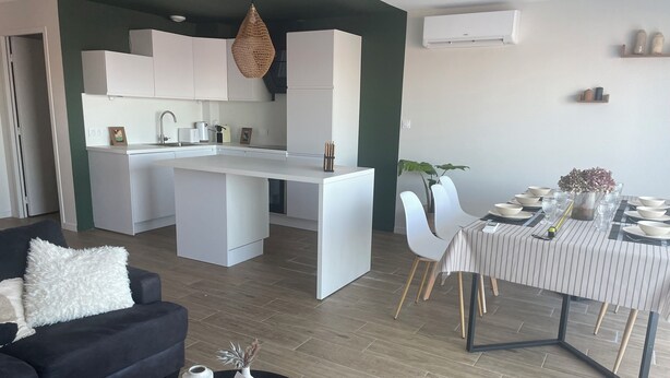 A modern apartment with a kitchen, dining area, and living room. - Sea view in the heart of Contis plage (Saint-Julien-en-Born)