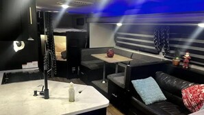 Un espace de vie compact comprenant un canapé, une petite table et un lit.