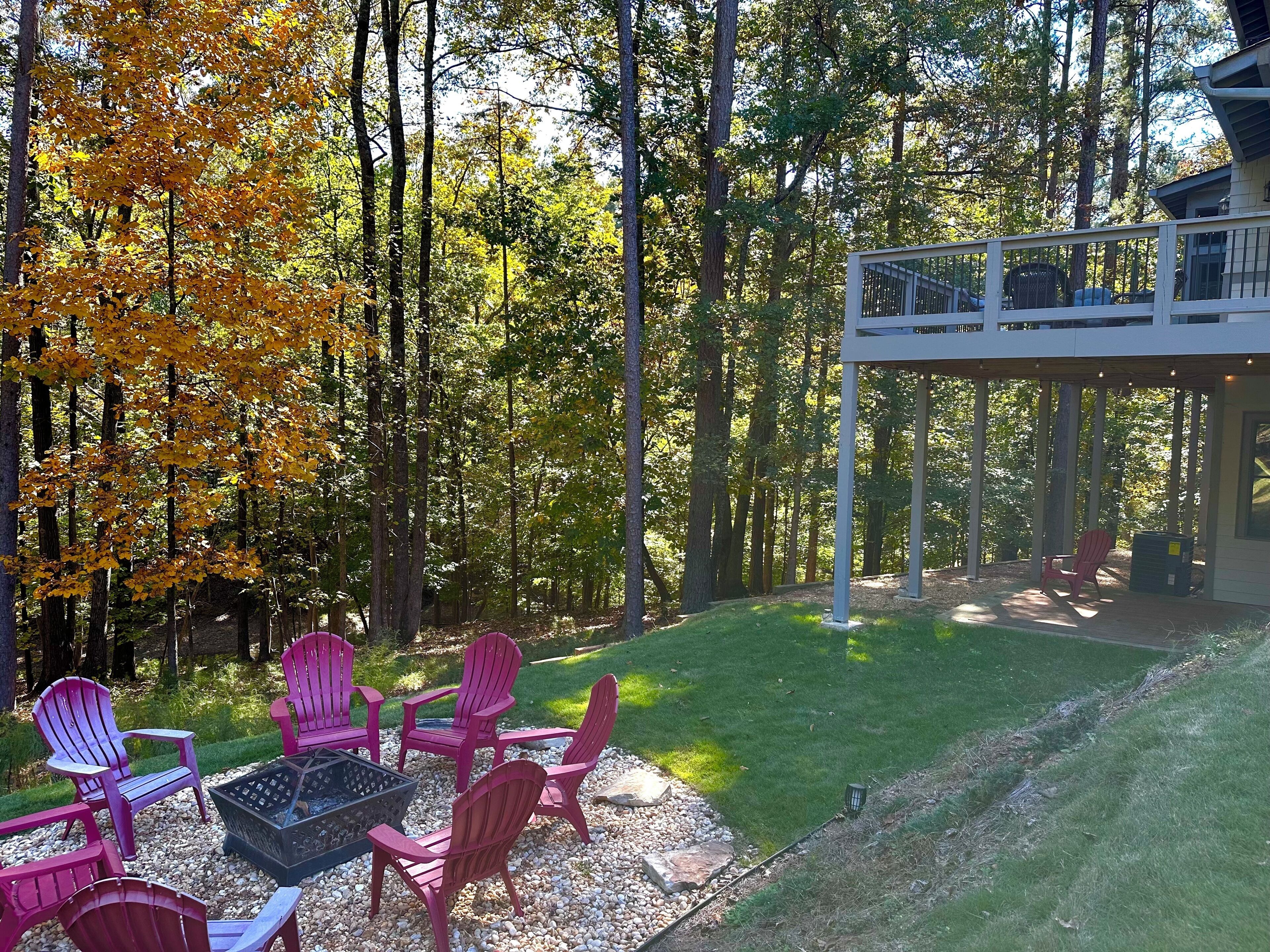 A backyard with a fire pit, outdoor seating, and a covered patio area.