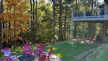 A backyard with a fire pit, outdoor seating, and a covered patio area.