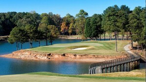 A golf course with a water body, trees, and a wooden bridge. - Buford Forest Retreat- Fire Pit - 5 bdrms- Sleeps 13 - Water Park, Venues, Golf! (Buford)