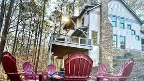 A cabin with a deck and a stone exterior. - Buford Forest Retreat- Fire Pit - 5 bdrms- Sleeps 13 - Water Park, Venues, Golf! (Buford)