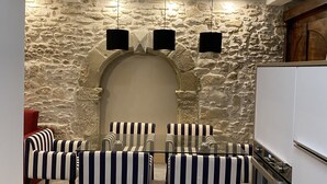 A dining area with striped chairs and a stone wall backdrop. - LA RENAUDIERE, HYPER CENTER (L'Isle-sur-la-Sorgue)