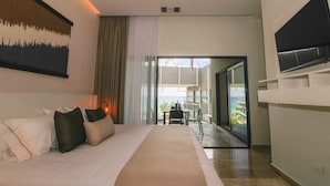 A modern hotel room with a large bed, a flat-screen TV, and a balcony with a view. - Singular Dream Vacation Rentals  (Playa del Carmen)