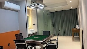 A conference room with a pool table, chairs, a glass partition, and a ceiling-mounted air conditioner. - Ganmu Gardens Hotel (Susong)