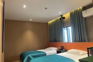 A hotel room with two beds, a nightstand, a desk, and a window with curtains. - Ganmu Gardens Hotel (Susong)