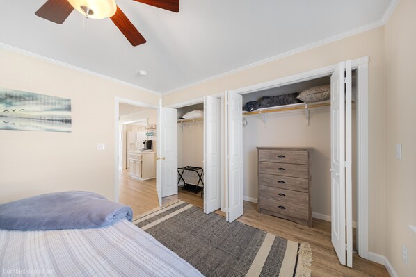 A bedroom with a bed, a ceiling fan, a wardrobe, and a desk with a chair. - Cozy Home 1 Mile to Downtown CDA & Lake – King Beds and an EV Charger! (Coeur d'Alene)