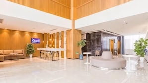 A modern lobby with a reception desk, seating area, and a large plant. - Jinjiang Inn Select (Qingdao Boli Dongjiakou) (Qingdao)
