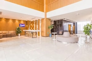 A modern lobby with a reception desk, seating area, and a large plant. - Jinjiang Inn Select (Qingdao Boli Dongjiakou) (Qingdao)