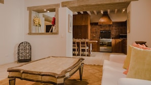 Una sala de estar con mesa de billar, sofá y comedor con sillas.