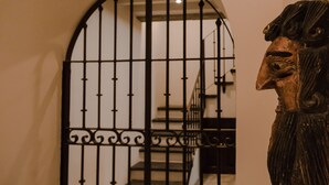 Una escalera con una reja de hierro forjado que da a un nivel superior.