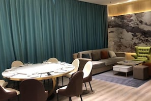 Un saló modern amb una taula rodona, sofàs i un armari verd.
