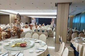 A banquet hall with round tables set for dining, featuring glassware and plates. - Master Hotel (Huidong)