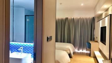 A hotel room with a large window, a bed, a desk, and a TV.