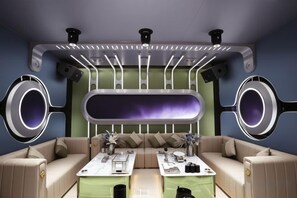 A modern interior with a sofa set, two tables, and a unique ceiling design with circular elements. - Master Hotel (Huidong)