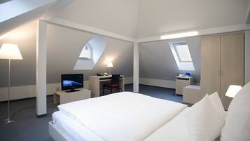 Ylelliset vuodevaatteet, untuvapeitot, tallelokero huoneessa, työpöytä