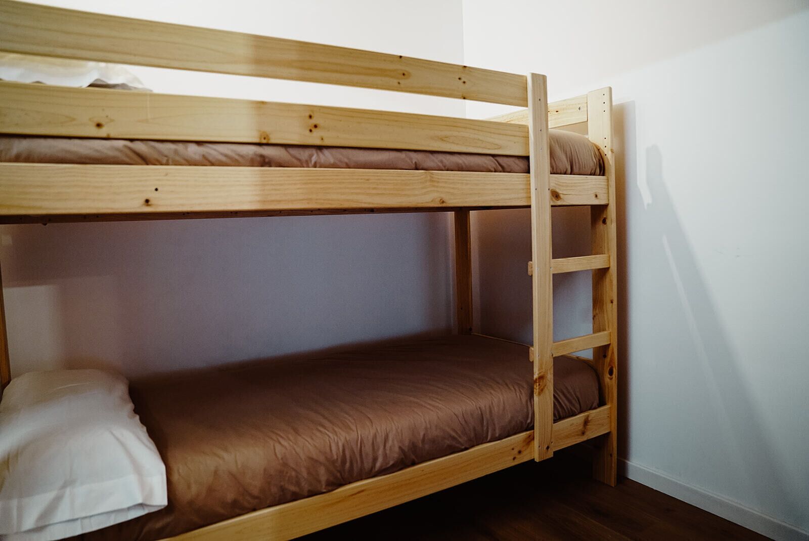 Een stapelbed met een ladder, een matras en een kussen.