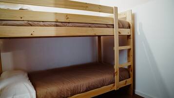 Een stapelbed met een ladder, een matras en een kussen.