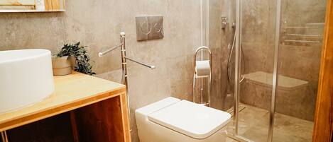Une salle de bain moderne équipée d’une douche, de toilettes et d’un lavabo.