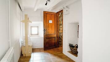Un couloir avec une porte en bois portant l’inscription « Suite de Lord », un radiateur, une fenêtre et un sol carrelé.
