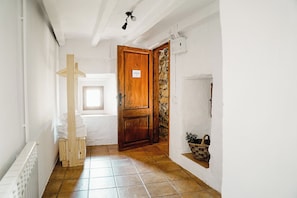 A hallway with a wooden door labeled 'Lord Suite,' a radiator, a window, and a tiled floor. - Cases Altes de Posada (Navès)