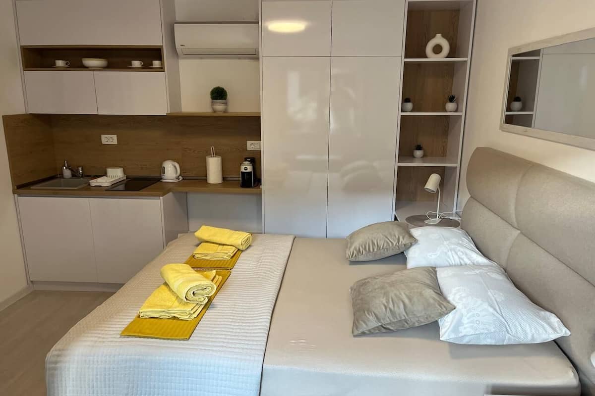 A compact bedroom with a bed, bedside tables, and a built-in wardrobe.