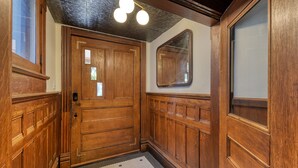 A wooden door with a small window, a textured ceiling, and a light fixture. - Experience History in Style in an 8BR/8BA Private Guesthouse! (Columbus)