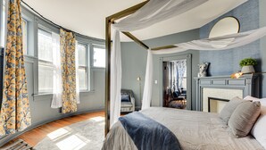 A bedroom with a four-poster bed, a fireplace, and a view of the outdoors. - Experience History in Style in an 8BR/8BA Private Guesthouse! (Columbus)