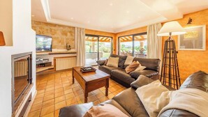 Ein Wohnzimmer mit Kamin, einer Couch, einem Couchtisch und einer Lampe.