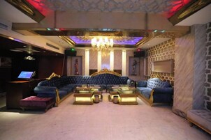 A luxurious lounge area with a large sofa, a coffee table, and a television.