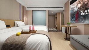 A hotel room with two beds, a TV, a small table, and a sofa. - Xiangxiang Hotel (Xiangxiang)