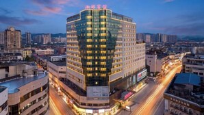 A high-rise hotel with multiple floors, a prominent sign at the top, and a cityscape in the background. - Xiangxiang Hotel (Xiangxiang)
