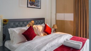Une chambre d’hôtel avec un lit, un ventilateur de plafond, une armoire et un tableau au mur.