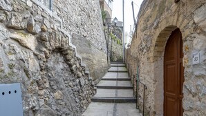 Eine schmale Steintreppe führt zu einer Tür mit dem Schild für Zimmer 83.