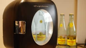 Musta jääkaappi, jossa on lasiovi, kaksi pulloa ”Tropicana”-mehua ja ”Frigidaire”-merkki.