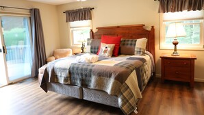 A bedroom with a wooden bed, a nightstand, a ceiling fan, and a window with curtains.