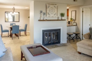 Una sala de estar con chimenea, un comedor con sillas y un sofá.