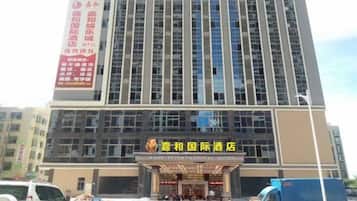 A tall hotel building with multiple floors and a prominent entrance.