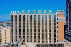 Un hôtel à plusieurs étages, doté d’une façade moderne, de grandes fenêtres et d’un toit plat.