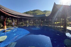 A traditional Japanese-style pool with a curved roof and stone lanterns.