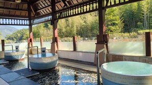 A traditional Japanese onsen with three hot tubs under a wooden pavilion, surrounded by a natural landscape. - Wugong Mountain Rongyuan International Hot Spring Resort (Anfu)