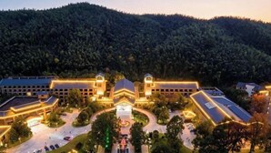 A large hotel with multiple buildings, a central courtyard, and a forested hill in the background. - Wugong Mountain Rongyuan International Hot Spring Resort (Anfu)