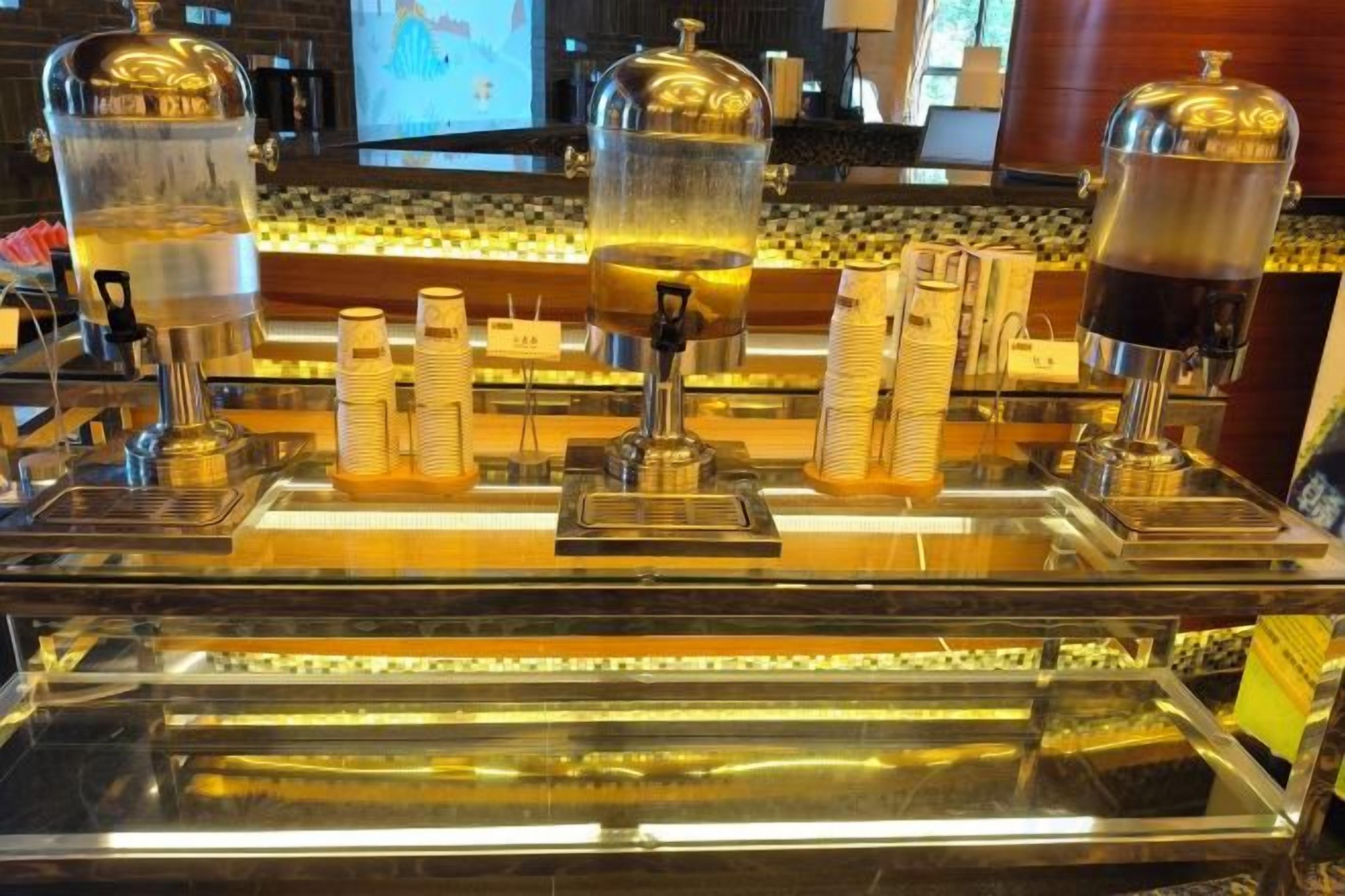 Un espace bar doté de plusieurs distributeurs de boissons et de piles de gobelets.