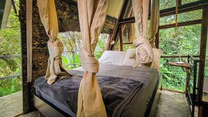 A bed with a canopy, a window, and a view of greenery. - Cerro Tusa Springs (Venecia)